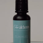 Black bottle with a teal label on a reflective surface