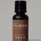 Tan alchemy bottle on a reflective surface with a neutral background