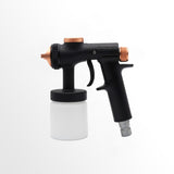 Black and copper spray gun with a white container on a white background