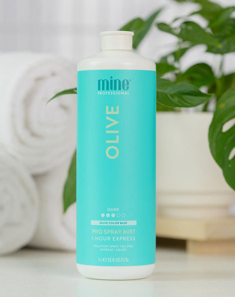 Blue bottle labeled 'Olive' with 'mine' branding on a blurred background