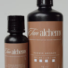 Two bottles of Tan alchemy Aussie Bronze tanning lotion on a light gray background