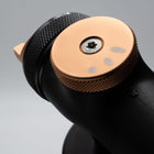 Close-up of a black and bronze tool head on a gray background