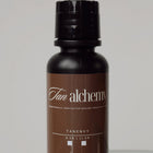 Brown bottle labeled 'Tan Alchemy' on a gray background