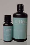 Two bottles of Tan Alchemy pre-tan prep spray on a gray background