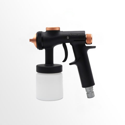 Black and copper spray gun with a white container on a white background