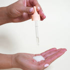 The person is using MineTan Illuminating Glow Drops