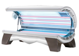 A commercial tanning bed with multiple high-output lamps arranged for even tanning coverage, featuring a mix of UV and red light lamps.