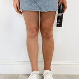 Person holding a bottle of 'I see the darkest possible' product with a white background