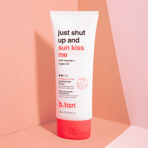 Tube of b.tan tanning lotion with text on a peach background
