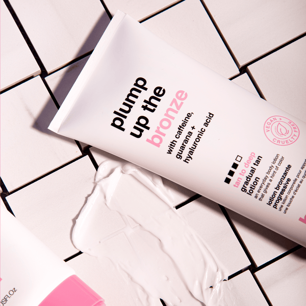 Cosmetic tube labeled 'plump up the bronze' on a tiled surface with visible product.