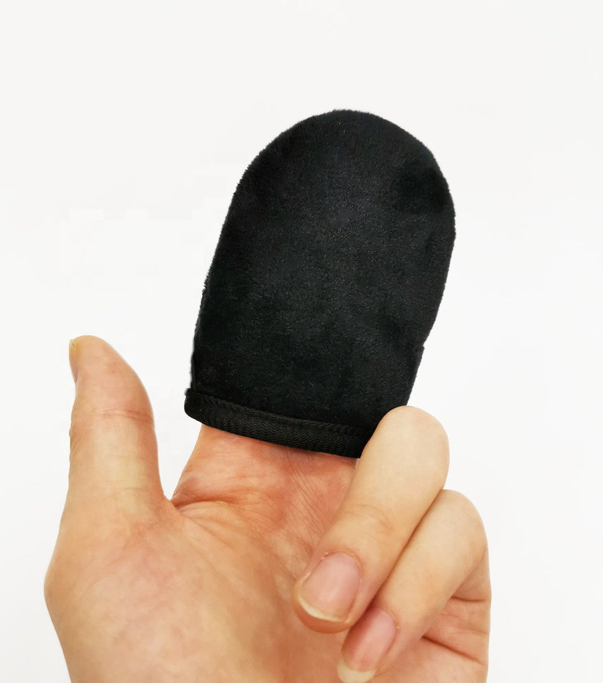 Black finger sleeve on a person's finger against a white background