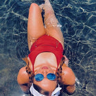Person in a red swimsuit and sunglasses floating in water with '#Rapid' text above.